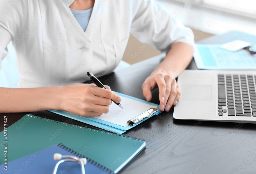 Fototapeta premium Young female doctor working in clinic, closeup