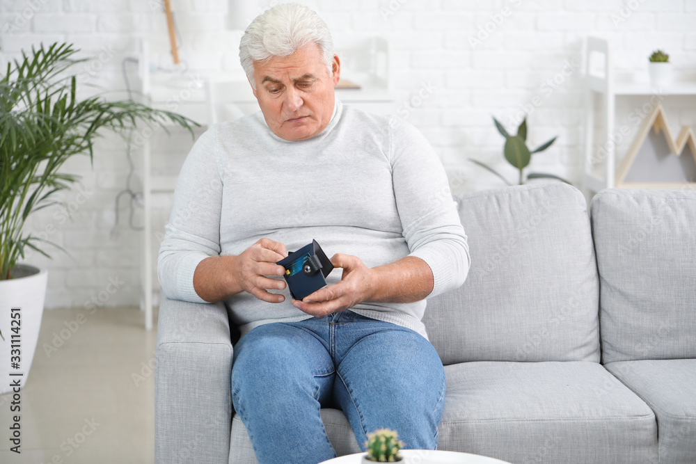Sad senior man with purse at home Sad senior man with purse at home