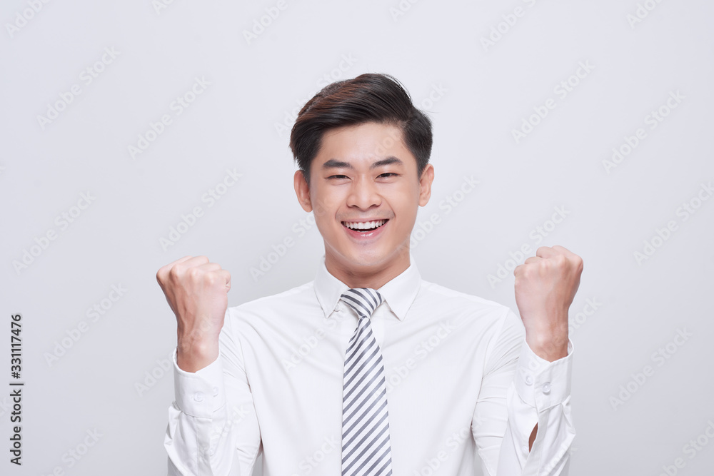 Portrait of victorious man looking up while standing on white background and celebrating with fists in the air Portrait of victorious man looking up while standing on white background and celebrating with fists in the air