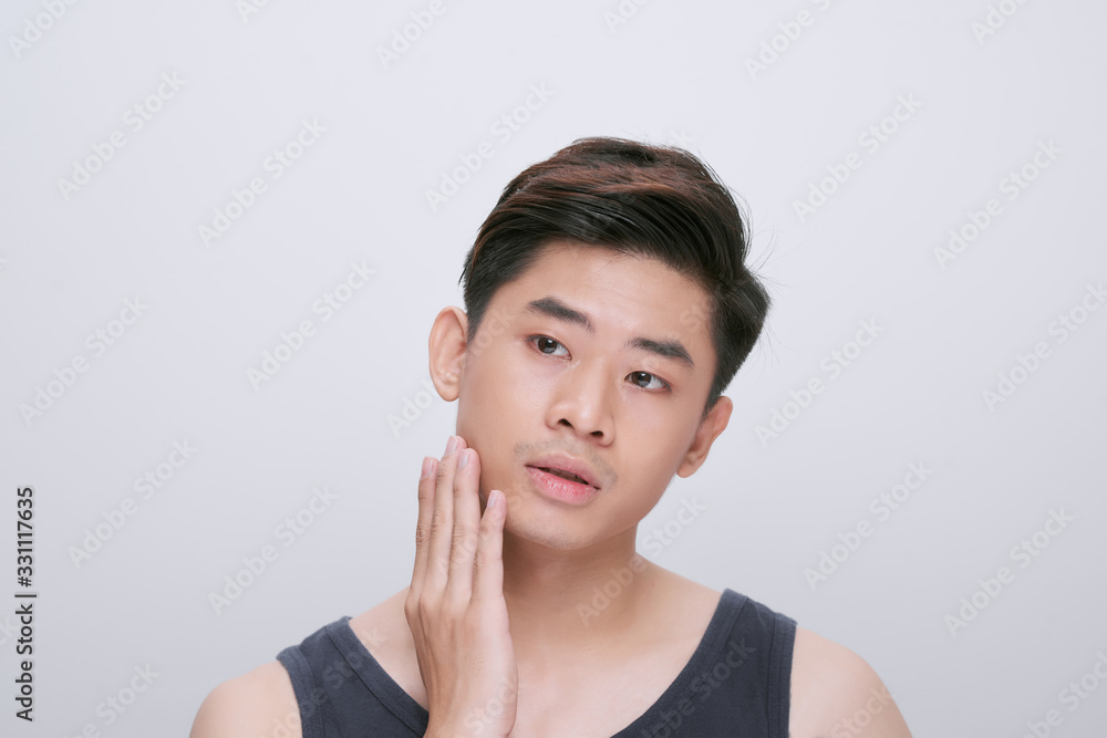 health and beauty concept - beautiful smiling man touching his face or applying cream health and beauty concept - beautiful smiling man touching his face or applying cream