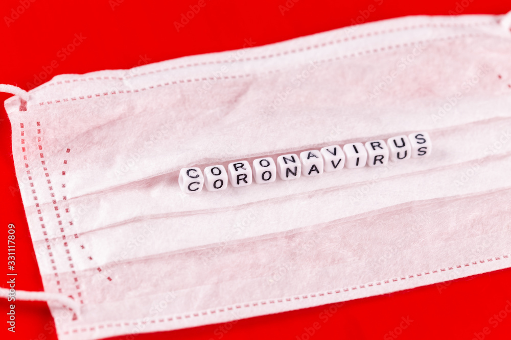 Obraz premium Coronavirus word made of letters on red background . The inscription on medical protective mask coronavirus.