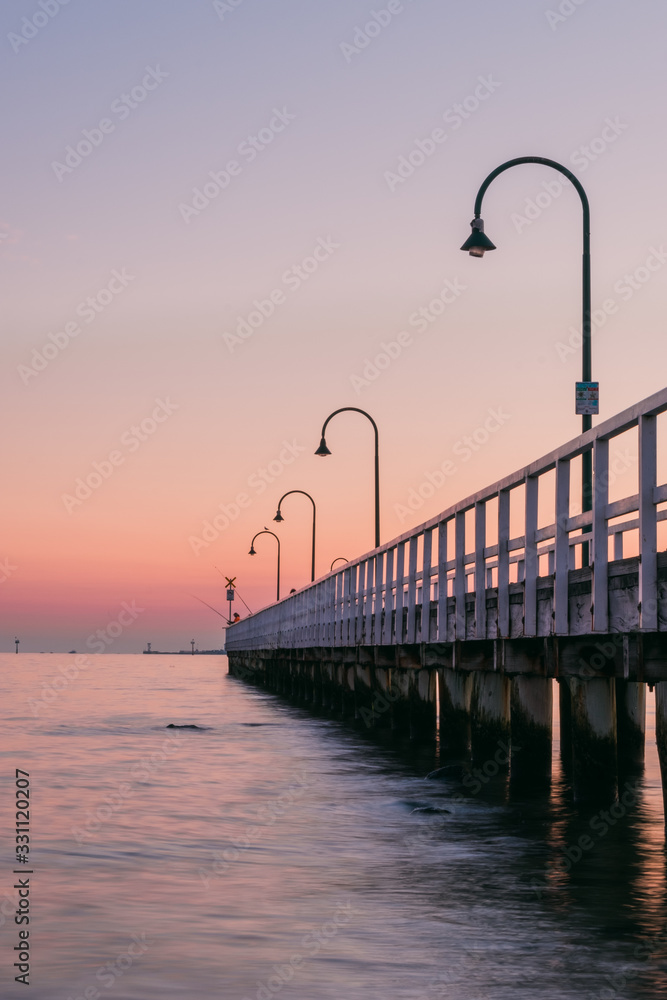 fishing on a pier at sunset