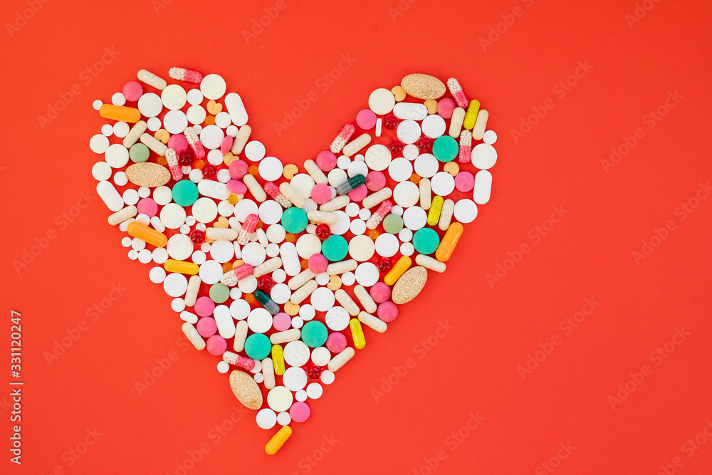 Danger for heart, medication,many colorful pills, capsules on red background.Diet and healthy lifestyle.Obesity leads to strokes, heart attacks,shortness of breath,psychological problems,adaptation in