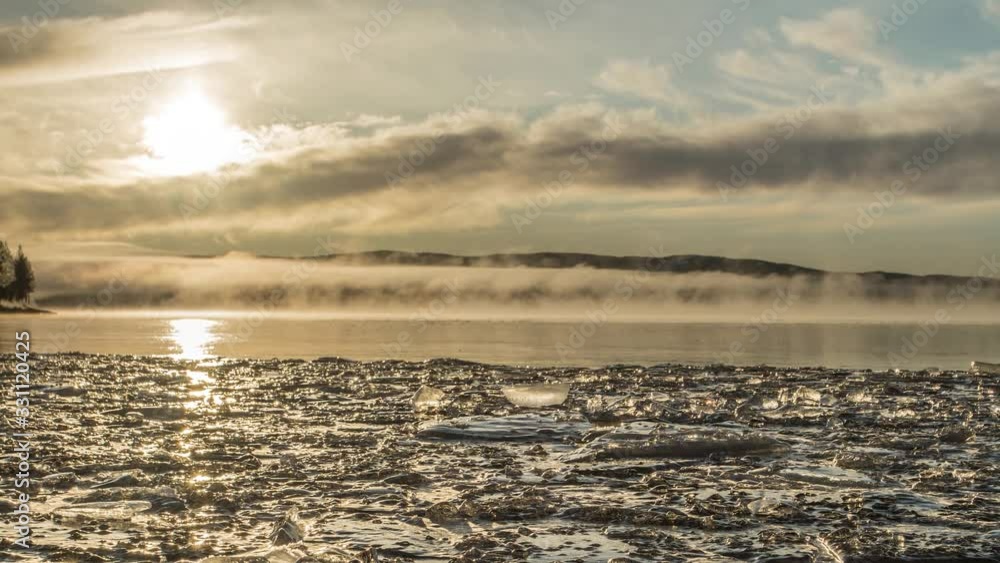 Frozen lake with morning mist and ice foreground rolling clouds Frozen lake with morning mist and ice foreground rolling clouds