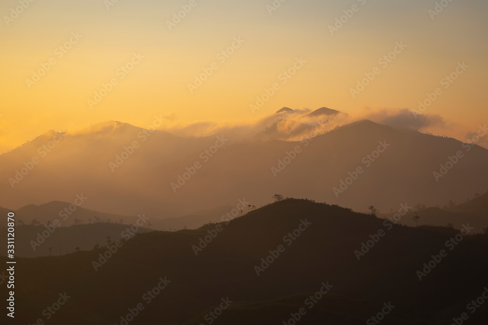 Landscape of the sunrise over the mountain with fog in the morning at Kanchanaburi provice , Thailand.