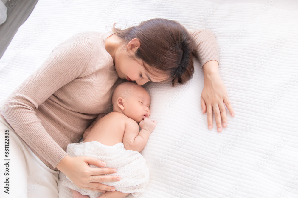 Asian beautiful mom motherhood lie down nursing, kissing newborn baby infant toddler, gently hold together on chest with love, infant sleep comfortable with safe and protection by mother taking care Asian beautiful mom motherhood lie down nursing, kissing newborn baby infant toddler, gently hold together on chest with love, infant sleep comfortable with safe and protection by mother taking care