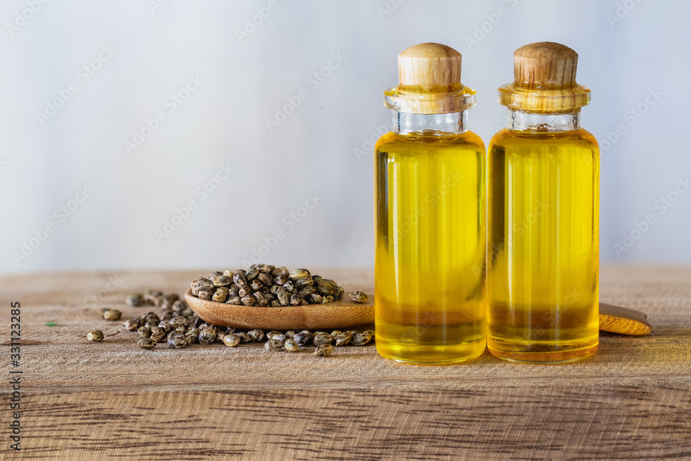  Hemp seeds in wooden spoon and hemp oil in a glass jar on brown wooden table. medical marijuana concept, CBD cannabis OIL.