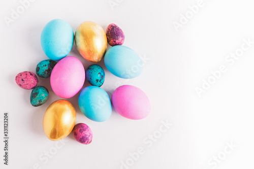 Happy easter concept. Big small eggs of various fashionable colors lie in a heap on a white background. Copy space