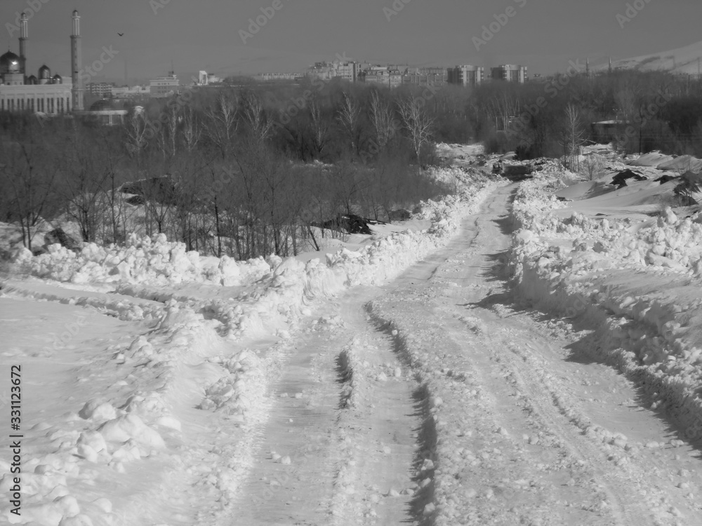 Ust-Kamenogorsk (Kazakhstan). Snowy country road. Winter steppe. City outskirts. Black and White