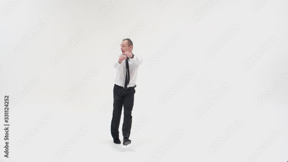 The businessman jumps up and puts his hand to his forehead looking into the distance. A male break dancer in office clothes dances waving his arms The businessman jumps up and puts his hand to his forehead looking into the distance. A male break dancer in office clothes dances waving his arms