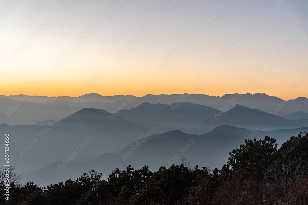 Stacked mountain ridges seen during golden hour of sunset from Poonhill Ghorepani Nepal