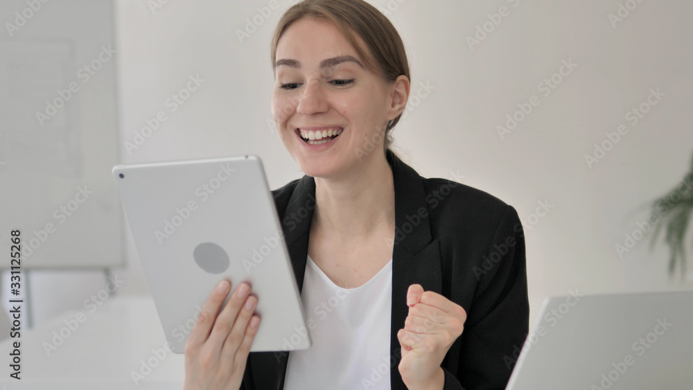 Young Businesswoman Celebrating Success on Tablet Young Businesswoman Celebrating Success on Tablet