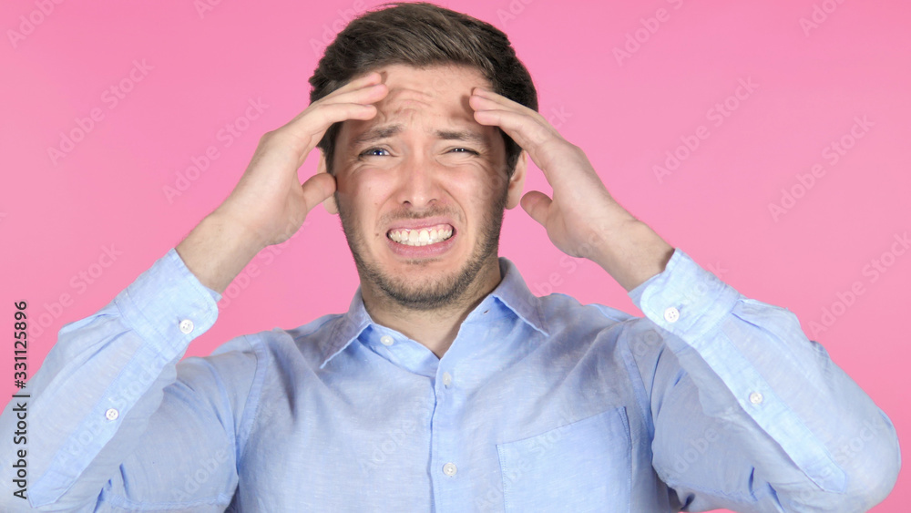 Young Man Upset by Failure on Pink Background Young Man Upset by Failure on Pink Background