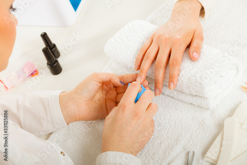 Woman getting manicure done file nails