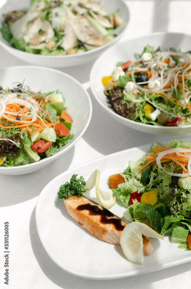 mixed fresh organic salads on white restaurant table mixed fresh organic salads on white restaurant table