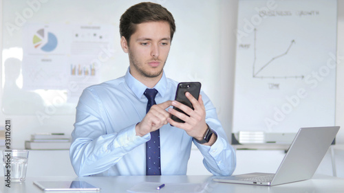 Young Businessman Using Smartphone, Typing Message