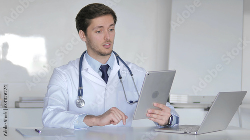Young Doctor Talking with Patient via Video Chat on Tablet