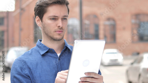 Outdoor Portrait of Young Man Using Tablet