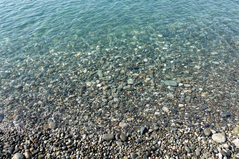 Sea stones in the sea water. Pebbles under water. The view from the top. Nautical background. Clean sea water. Transparent sea. Sea stones in the sea water. Pebbles under water. The view from the top. Nautical background. Clean sea water. Transparent sea.