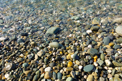 Pebble beach. Sea view. Sea shore with calm clear water