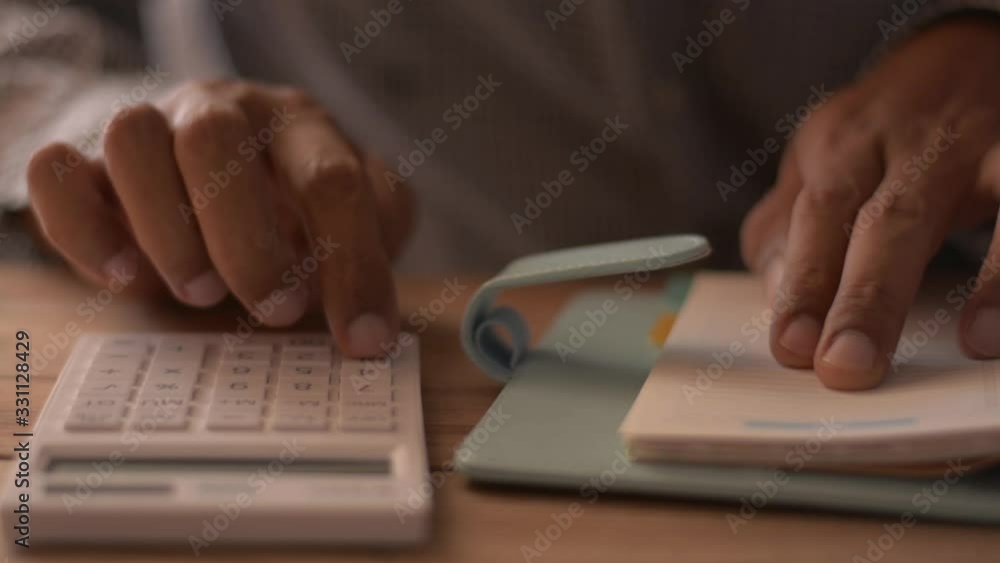 Close up hands of man calculating expenses on the desk. Finances, investment, economy, saving money or insurance concept. Close up hands of man calculating expenses on the desk. Finances, investment, economy, saving money or insurance concept.