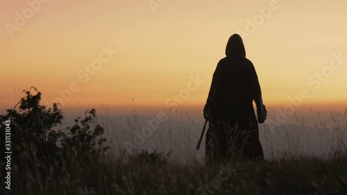 Epic fantasy warrior standing with sword in field photo