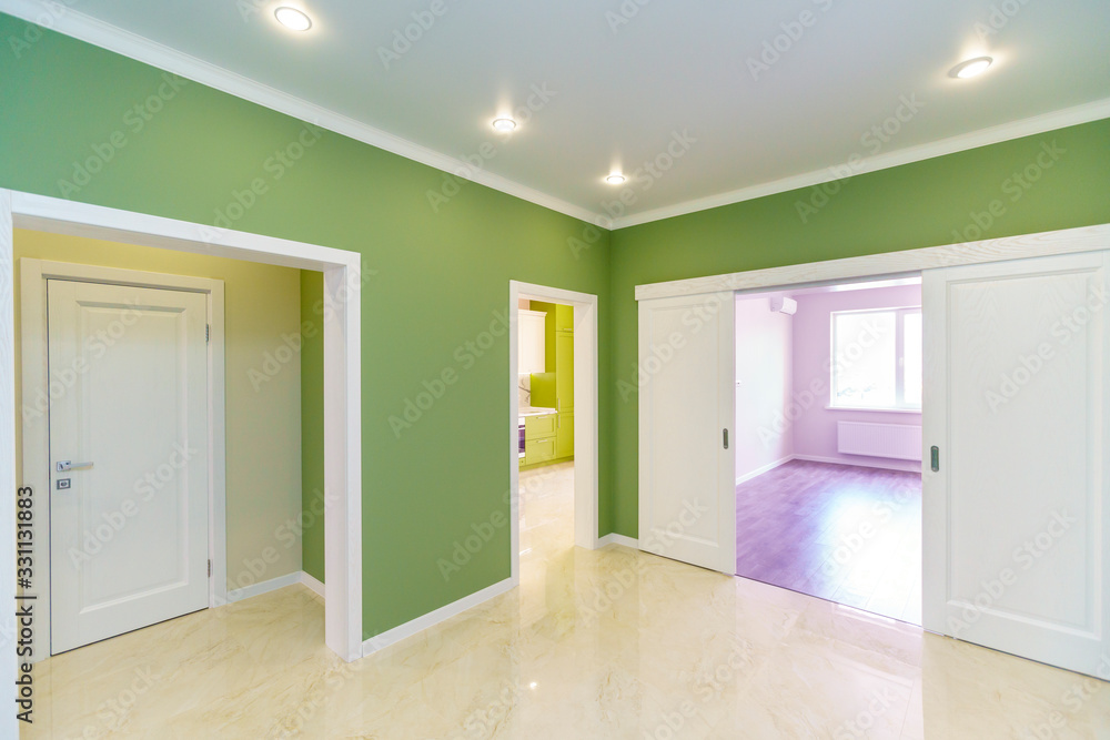 Empty hallway with green walls and marble floor in a new apartment with a fresh renovation. Doors lead from the hall to different rooms. Empty hallway with green walls and marble floor in a new apartment with a fresh renovation. Doors lead from the hall to different rooms.