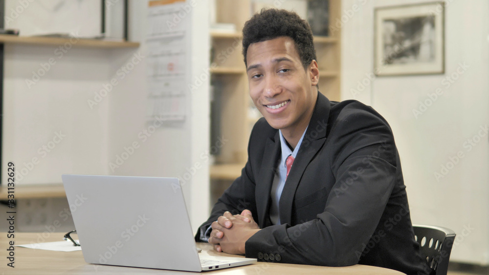Smiling Young African Businessman Sitting at Work Smiling Young African Businessman Sitting at Work
