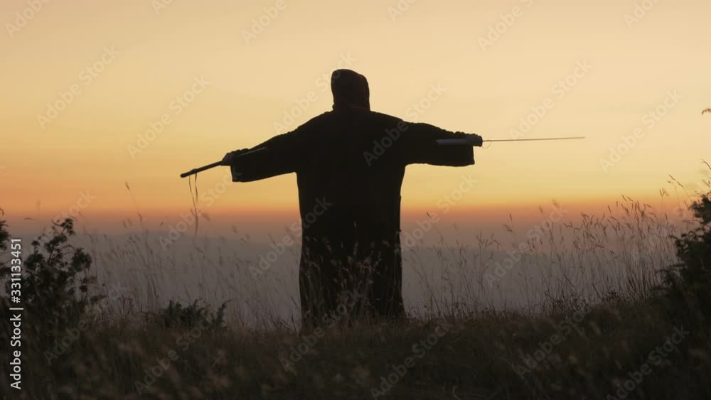 Epic fantasy warrior standing with sword in battlefield Epic fantasy warrior standing with sword in battlefield