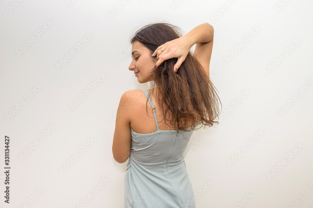 Naklejka premium Fashion woman in elegant dress touching her hair. Sensual portrait of attractive woman