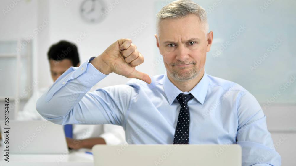 Thumbs Down by Grey Hair Businessman in Office Thumbs Down by Grey Hair Businessman in Office