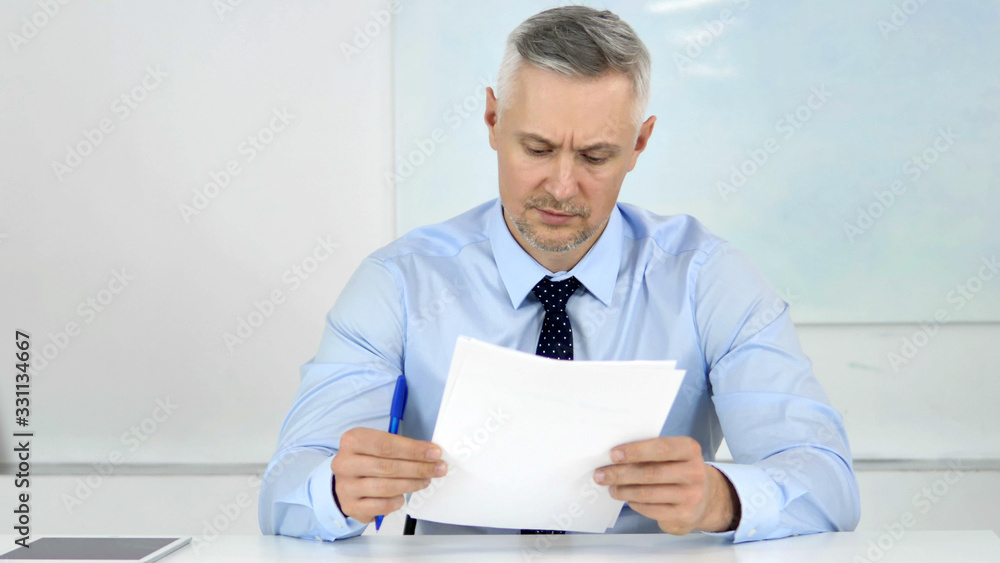 Senior Businessman Reading Documents in Office, Contract Senior Businessman Reading Documents in Office, Contract