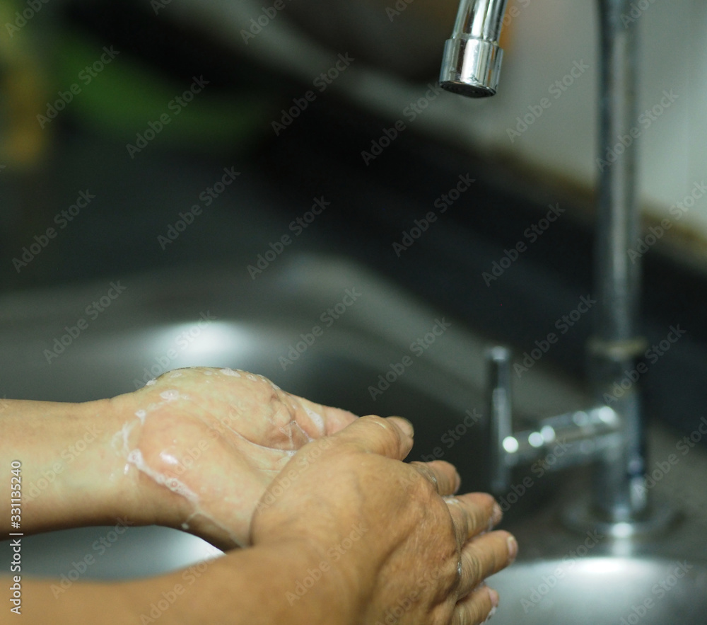 OLYMPUSA woman standing and washing her hands at the sink to prevent germs protect colona virus, covid 19 DIGITAL CAMERA OLYMPUSA woman standing and washing her hands at the sink to prevent germs protect colona virus, covid 19 DIGITAL CAMERA