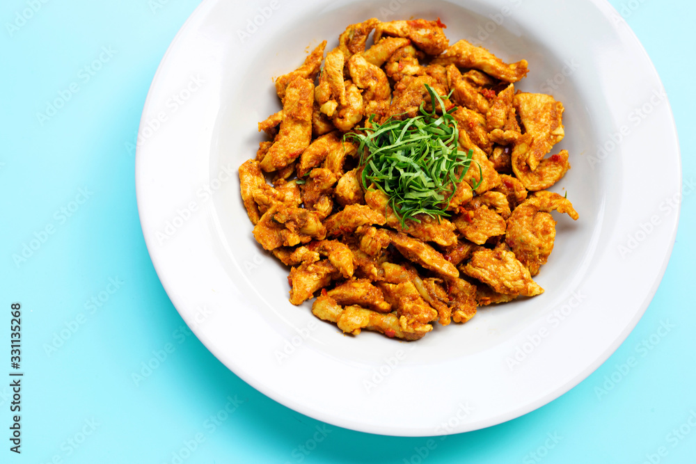 Chicken with yellow curry paste on blue background. Chicken with yellow curry paste on blue background.