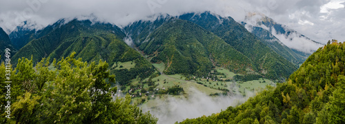 Summer mountains green forest and blue sky with clouds landscape. Aerial panoramic photo of Caucasian mountains, top view. Travel and vacation concept.