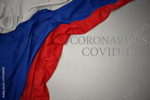 waving national flag of russia on a gray background with text coronavirus covid-19 . concept.