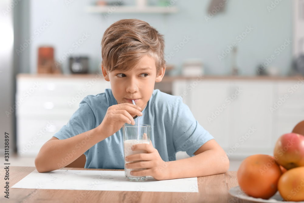 Little boy drinking milk in kitchen Little boy drinking milk in kitchen