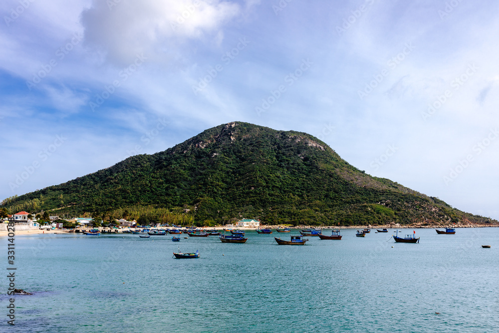 Traditional Asian fishing boats stand in a welcoming bay. Travel in Vietnam