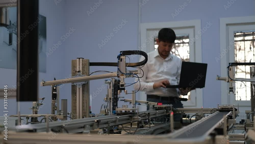 Industry 4.0 concept; Engineer is working on laptop to program smart factory prototype's automation. automated car on production line, artificial intelligence in smart manufacturing. Industry 4.0 concept; Engineer is working on laptop to program smart factory prototype's automation. automated car on production line, artificial intelligence in smart manufacturing.