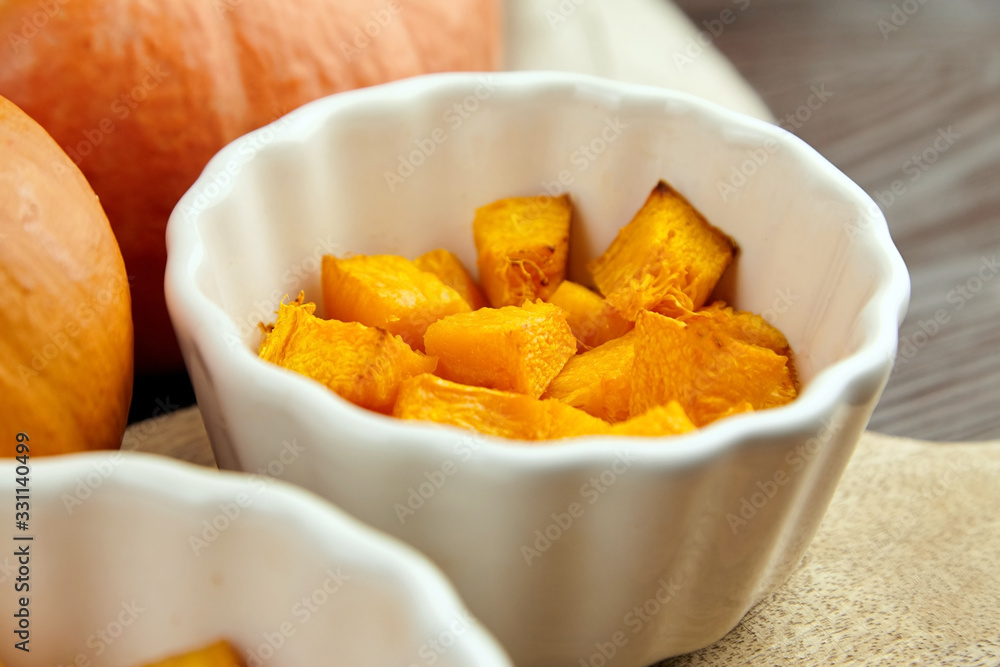 Pieces of baked pumpkin in white ceramic bowl on wooden background Pieces of baked pumpkin in white ceramic bowl on wooden background