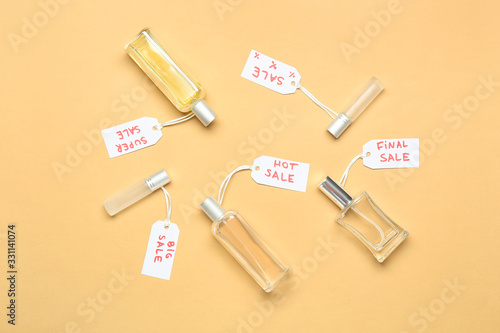 Bottles of perfumes for sale on color background