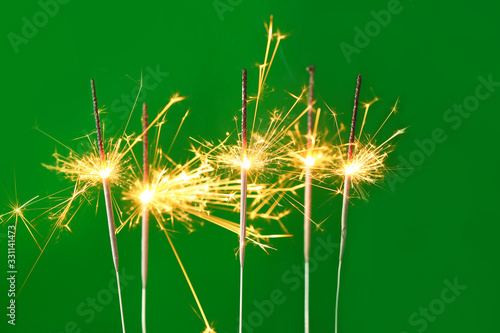 Beautiful Christmas sparklers on color background