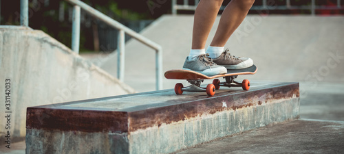 Skateboarder legs skating at skatepark