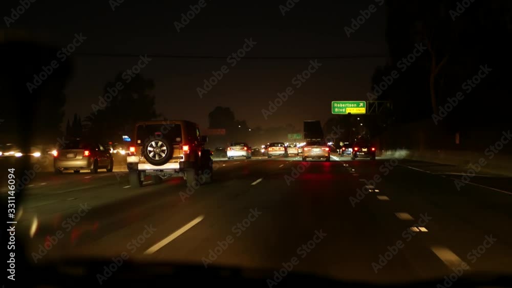 View from the car. Los Angeles busy freeway at night time. Massive Interstate Highway Road in California, USA. Auto driving fast on Expressway lanes. Traffic jam and urban transportation concept View from the car. Los Angeles busy freeway at night time. Massive Interstate Highway Road in California, USA. Auto driving fast on Expressway lanes. Traffic jam and urban transportation concept