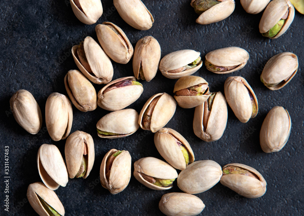Roasted pistachios nuts on dark background. Healthy snack