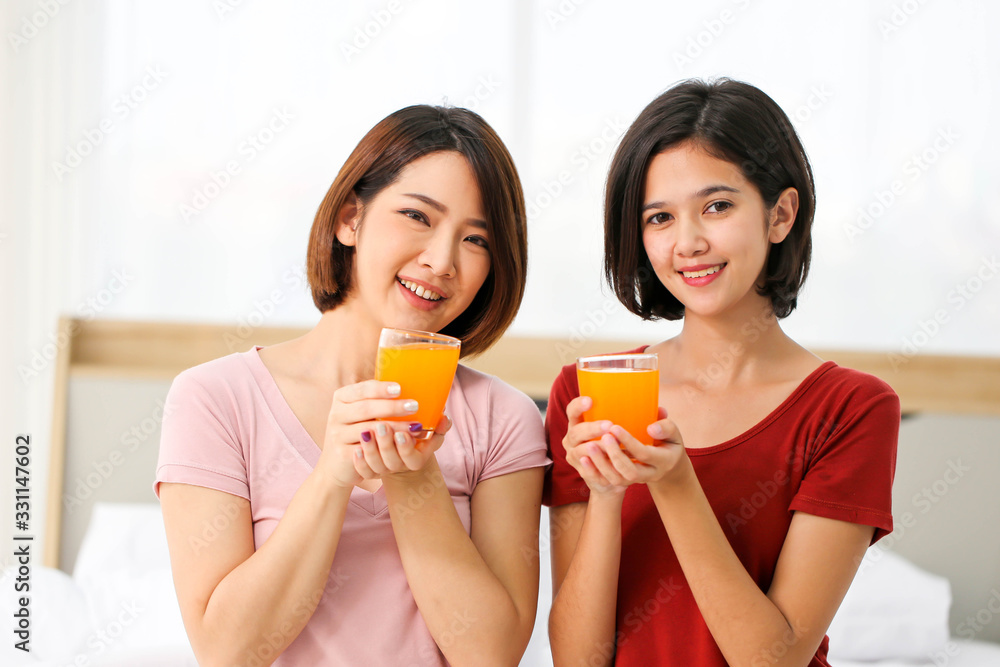 Happy young couple friend beautiful asia women drinking orange juice enjoying fruit refreshment ,Healthy lifestyle concept. Happy young couple friend beautiful asia women drinking orange juice enjoying fruit refreshment ,Healthy lifestyle concept.