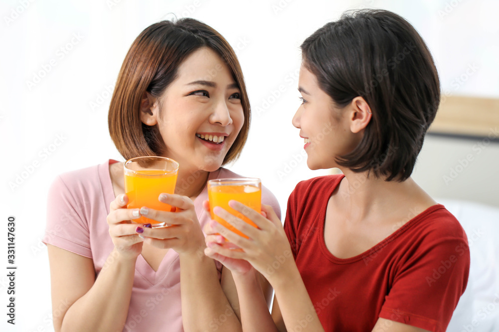 Happy young couple friend beautiful asia women drinking orange juice enjoying fruit refreshment ,Healthy lifestyle concept. Happy young couple friend beautiful asia women drinking orange juice enjoying fruit refreshment ,Healthy lifestyle concept.