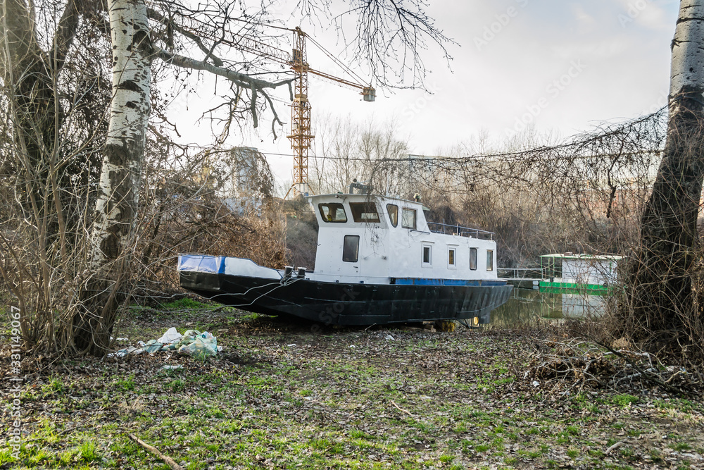Novi Sad, Serbia - February 08. 2020: Metal boat on the bank of the Danube River Novi Sad, Serbia - February 08. 2020: Metal boat on the bank of the Danube River