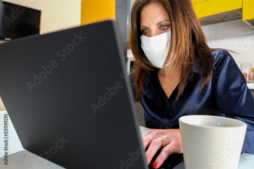 Coronavirus. Beautiful Business Woman in quarantine for corona virus working at home wearing protective mask