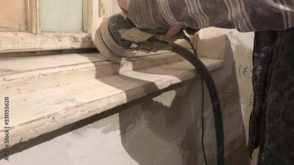 Closeup of man caught in action working with sander machine on white